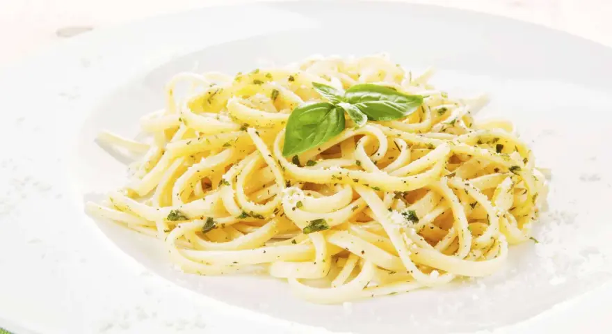 Ein Teller Spaghetti mit Kräutern und Parmesan, garniert mit Basilikum. Perfekt für einfache Spaghetti Rezepte.