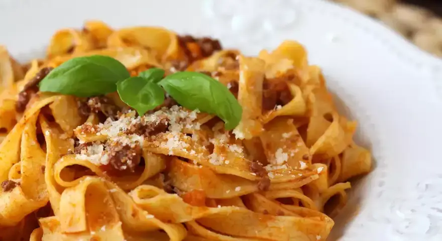 Breite Bandnudeln mit herzhaftem Ragout Bolognese, garniert mit frischem Basilikum und Parmesan. Ein Klassiker, der immer schmeckt.