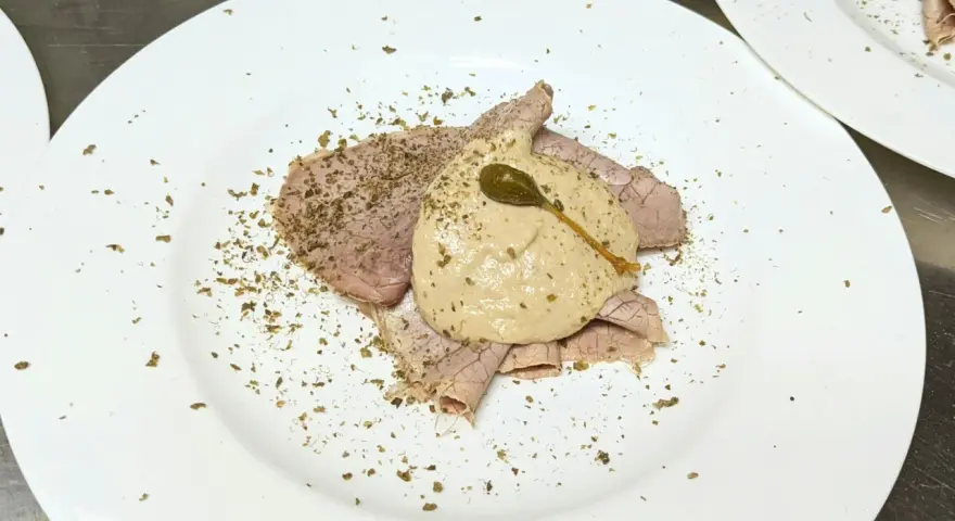 Dünne Scheiben Braten mit einer cremigen thunfischsauce italienisch, garniert mit Kapern und Kräutern.