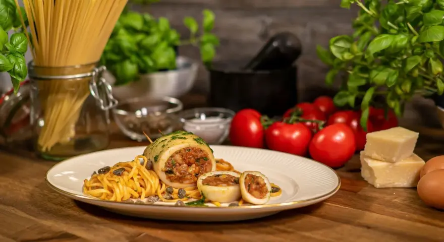 Seppie ripiene auf Pasta mit Kapern, Tomaten und Parmesan.