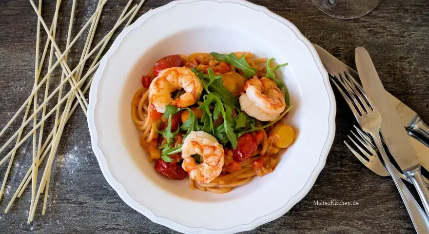 Ein köstliches garnelen italienisch rezept: Spaghetti mit Garnelen, Kirschtomaten und Rucola in einer cremigen Sauce.