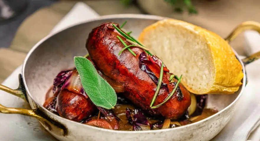 Herzhafte italienische Bratwurst Salsiccia mit Rotkohl und Brot. Ein köstliches Rezept für Salsiccia.