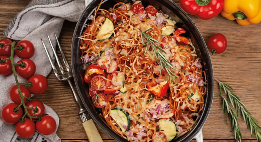 Herzhaftes Spaghetti al Forno mit Tomaten, Zucchini und Paprika, überbacken mit Käse und garniert mit Rosmarin.