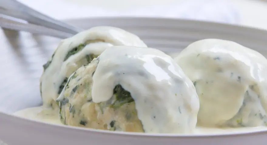 Drei Klöße mit Spinat, übergossen mit einer cremigen Gorgonzolasauce. Ein italienisches Original-Rezept für Genießer.
