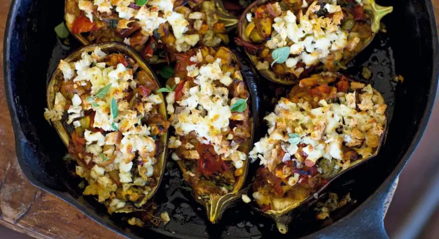 Melanzane ripiene, gefüllt mit Gemüse und Käse, in einer Gusseisenpfanne.
