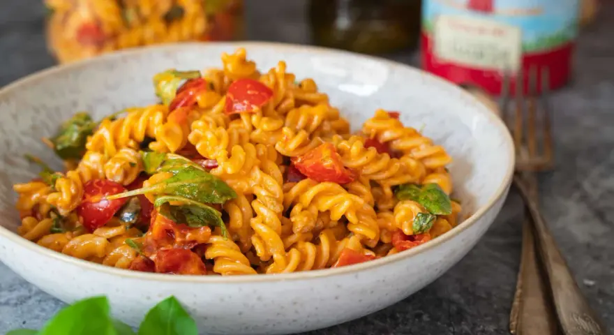 Fusilli-Nudeln mit Kirschtomaten und Basilikum in einer cremigen Sauce, die nach salat mit pesto schmeckt.
