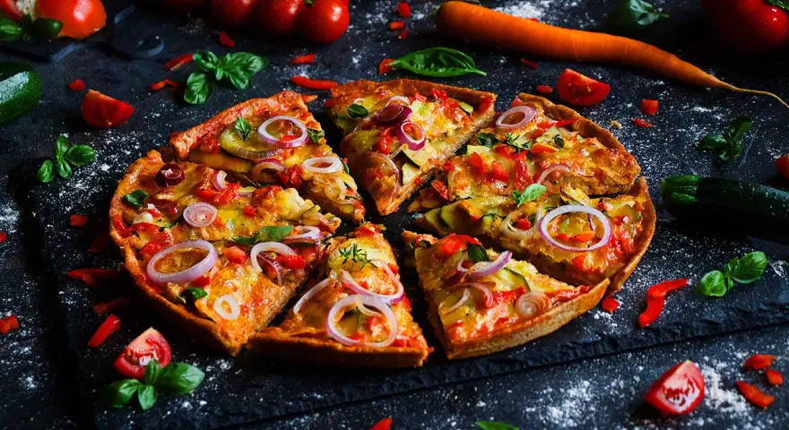 Leckere Pizza mit Gemüse, perfekt für ein Pizza backen Rezept. Frische Tomaten, Zucchini und rote Zwiebeln machen sie unwiderstehlich.