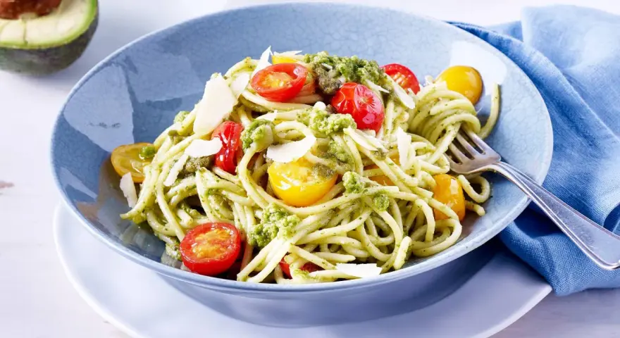 Spaghetti mit cremigem Avocado Pesto, Kirschtomaten und Parmesan.