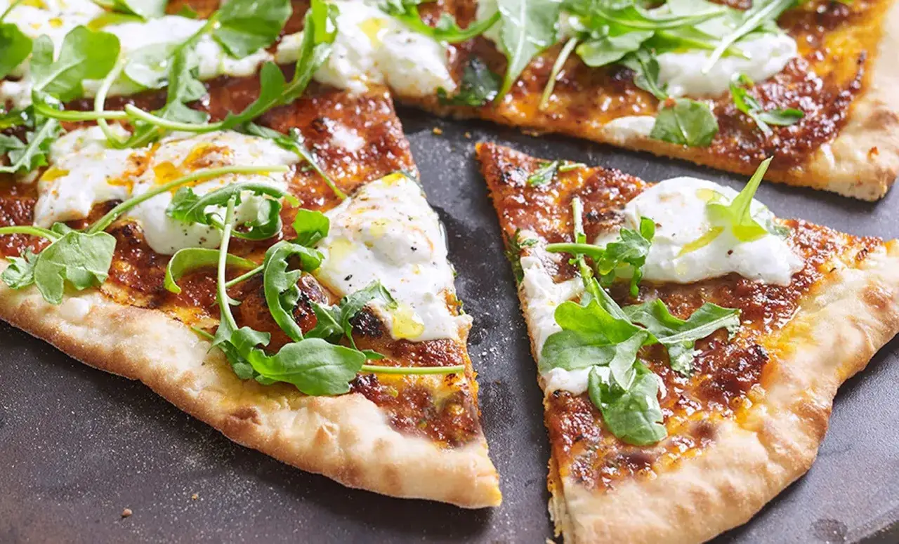 Eine k&ouml;stliche Nduja Pizza mit cremigem Mozzarella und frischem Rucola, bereit zum Genie&szlig;en.