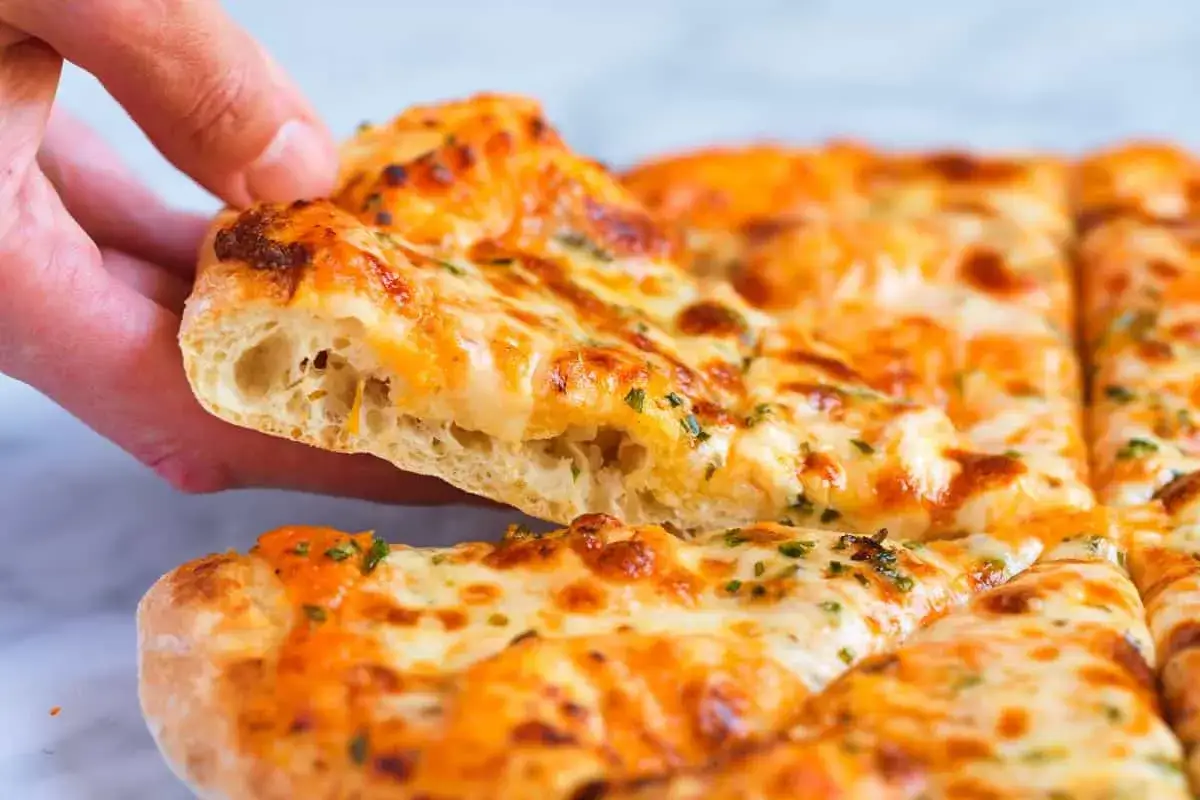 Ein Stück fluffige Pizza, perfekt für ein Caputo Nuvola Rezept. Der Teig ist luftig und der Käse goldbraun.