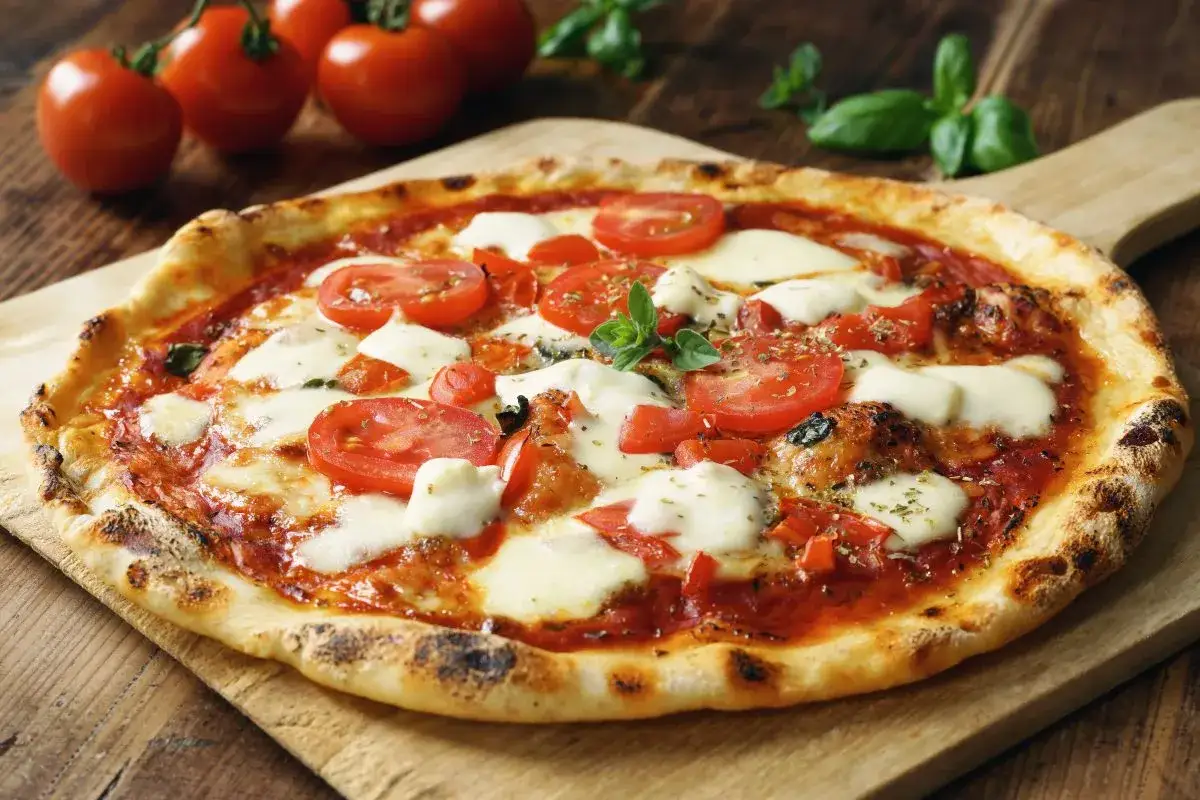 Frische Pizza Margherita mit Tomaten und Mozzarella, ein klassischer italienischer pizzabelag.