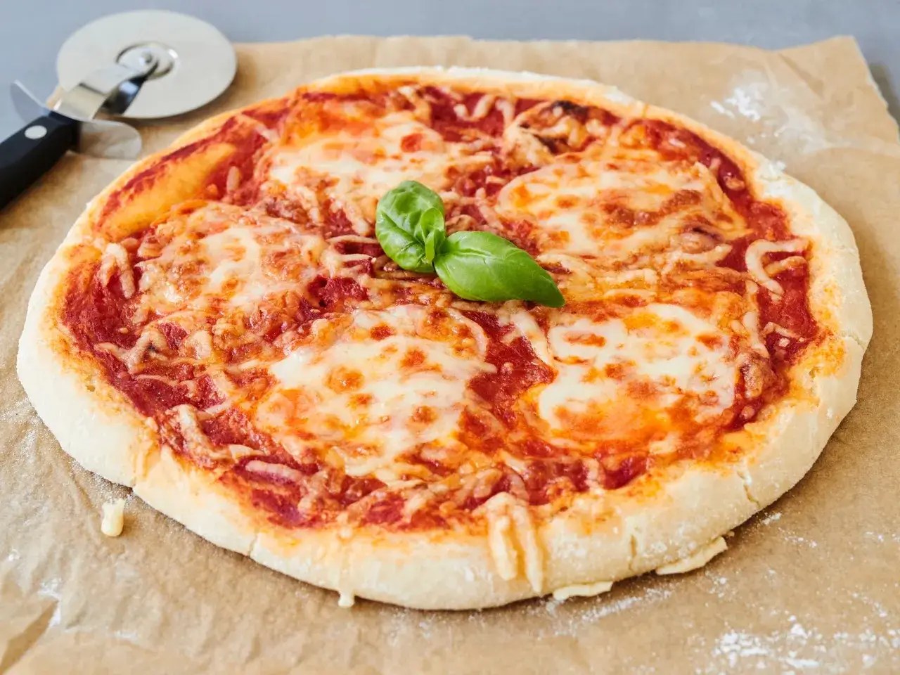 Eine k&ouml;stliche, frisch gebackene glutenfreie Pizza mit geschmolzenem K&auml;se und Basilikum. Perfekt f&uuml;r ein einfaches glutenfreies Pizza Rezept.