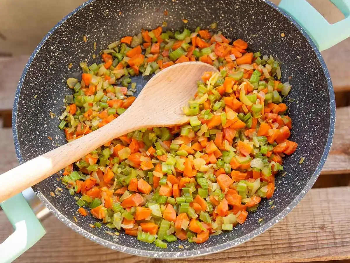 W&uuml;rziges Sofrito-Rezept in der Pfanne: Karotten, Sellerie und Zwiebeln werden f&uuml;r eine k&ouml;stliche Basis zubereitet.