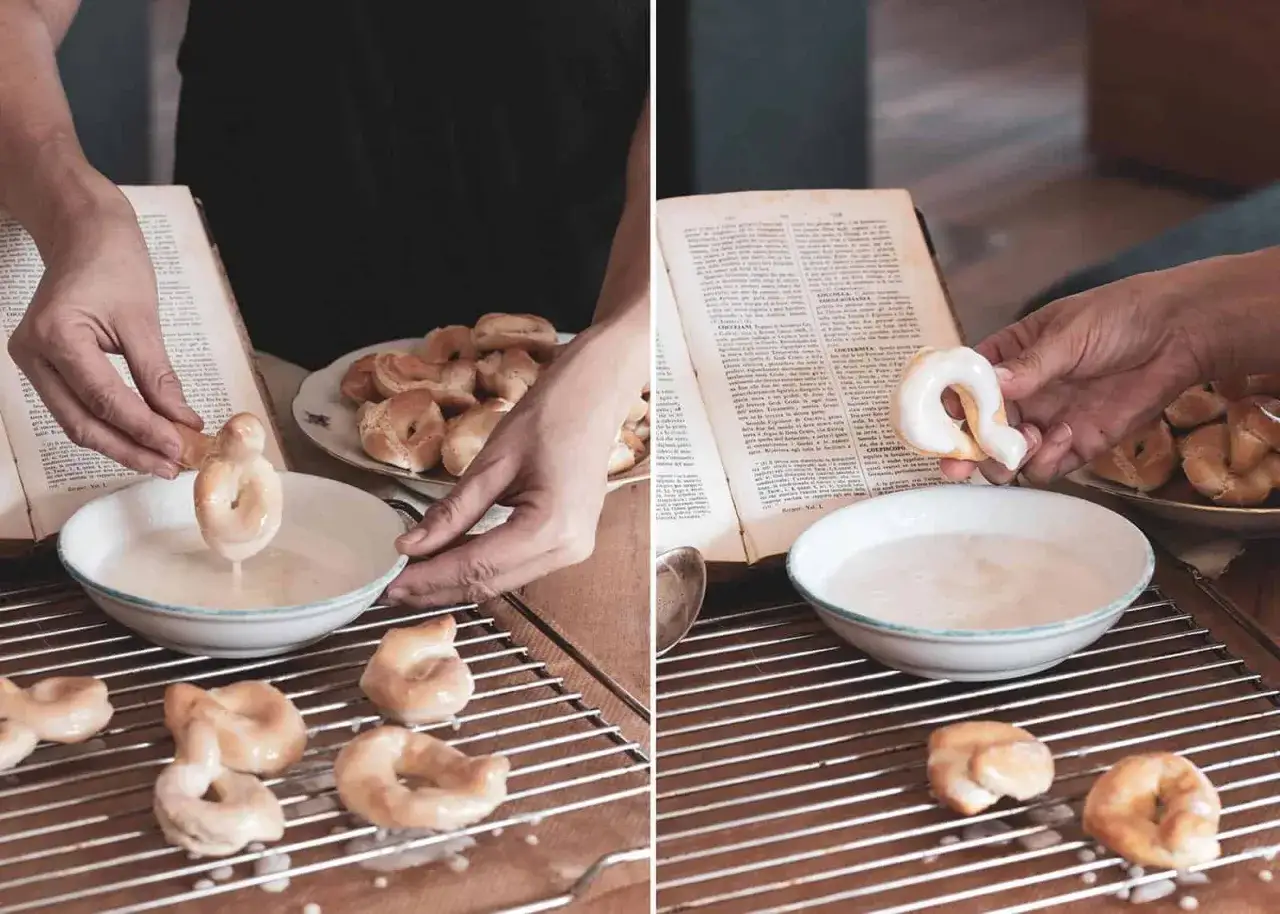 Hände tauchen Taralli in eine Glasur, inspiriert von einem alten Rezeptbuch. Ein köstliches Taralli-Rezept zum Nachbacken.