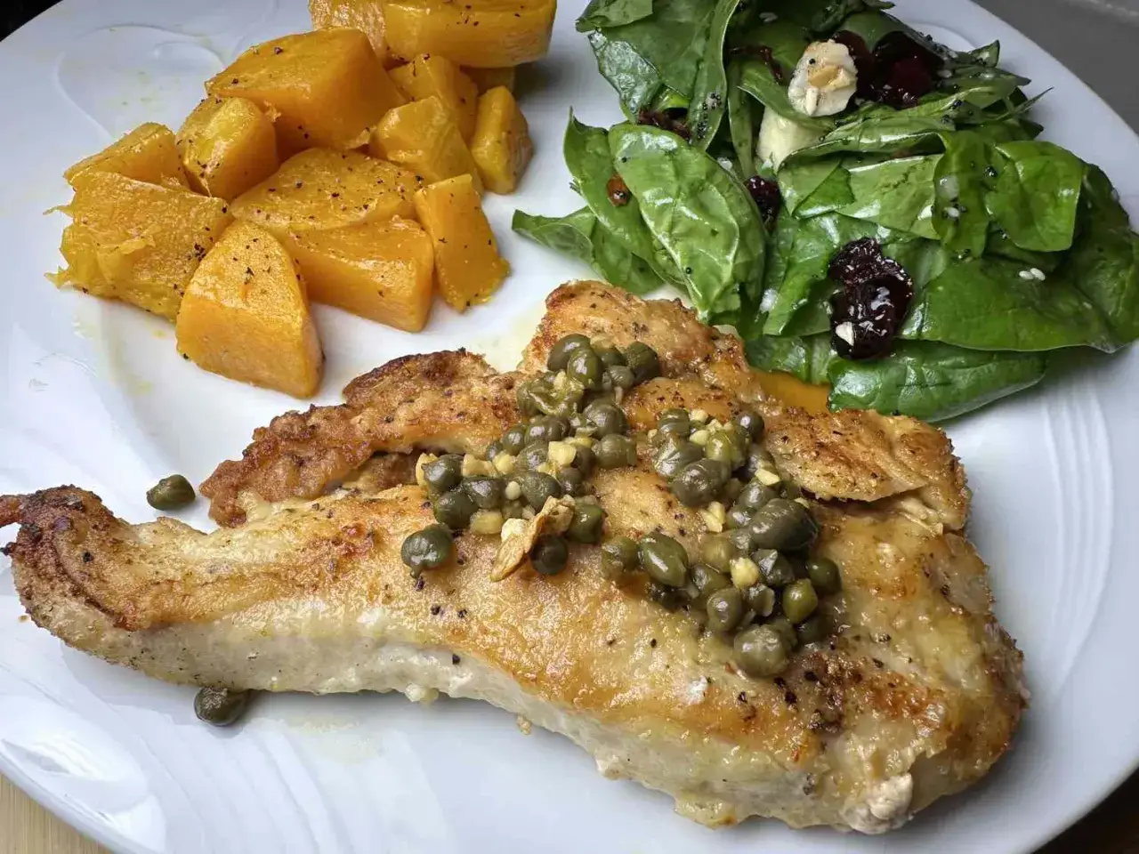 Gebratenes Hähnchen mit Kapern, dazu Kürbis und Spinatsalat. Ein köstliches Gericht, das an italienische Rezepte mit Kapern erinnert.
