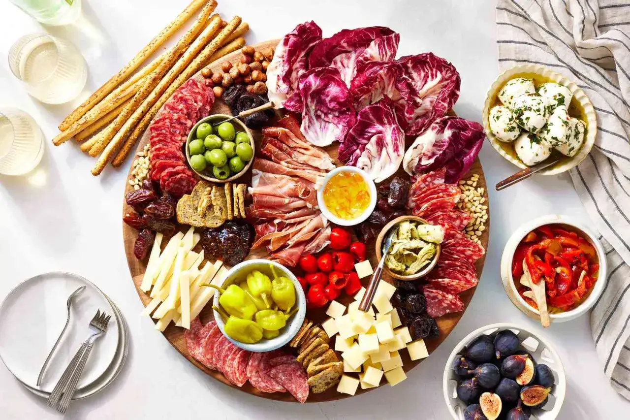 Ein Festmahl mit Wurst, K&auml;se, Oliven, Fr&uuml;chten und Brot. Ein Glas Wein dazu &ndash; f&uuml;r die Gesundheit!
