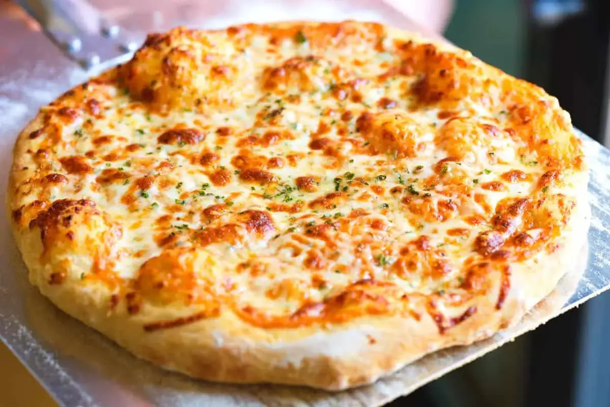 Eine k&ouml;stliche Pizza Formaggi mit geschmolzenem K&auml;se und Kr&auml;utern, bereit zum Servieren.