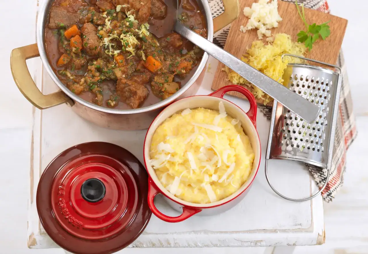 Herzhaftes Ossobuco vom Rind auf sizilianische Art, serviert mit cremiger Polenta und frisch geriebener Zitronenschale.