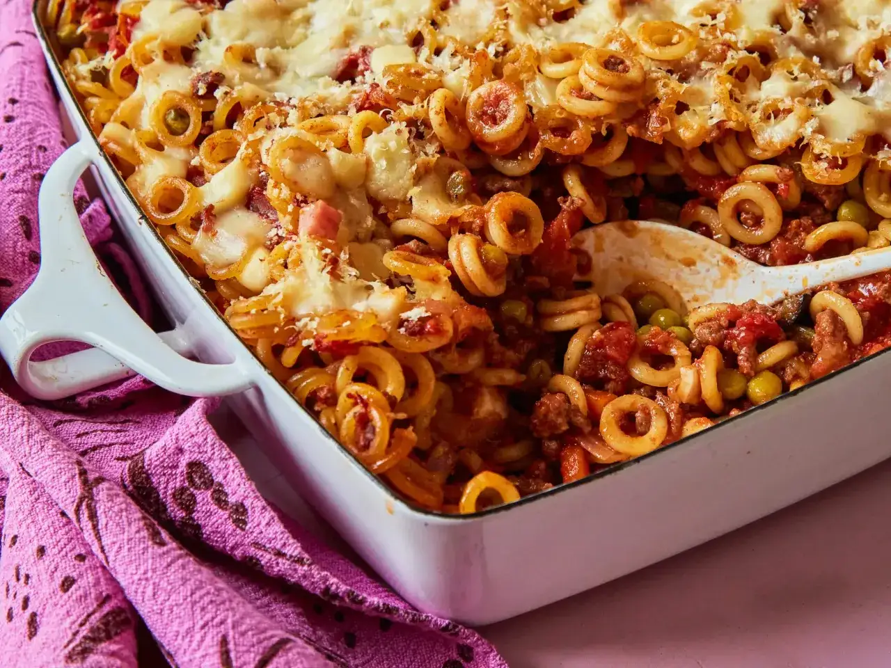 Herzhaftes Spaghetti al Forno mit geschmolzenem K&auml;se, Erbsen und Hackfleisch in einer Auflaufform.