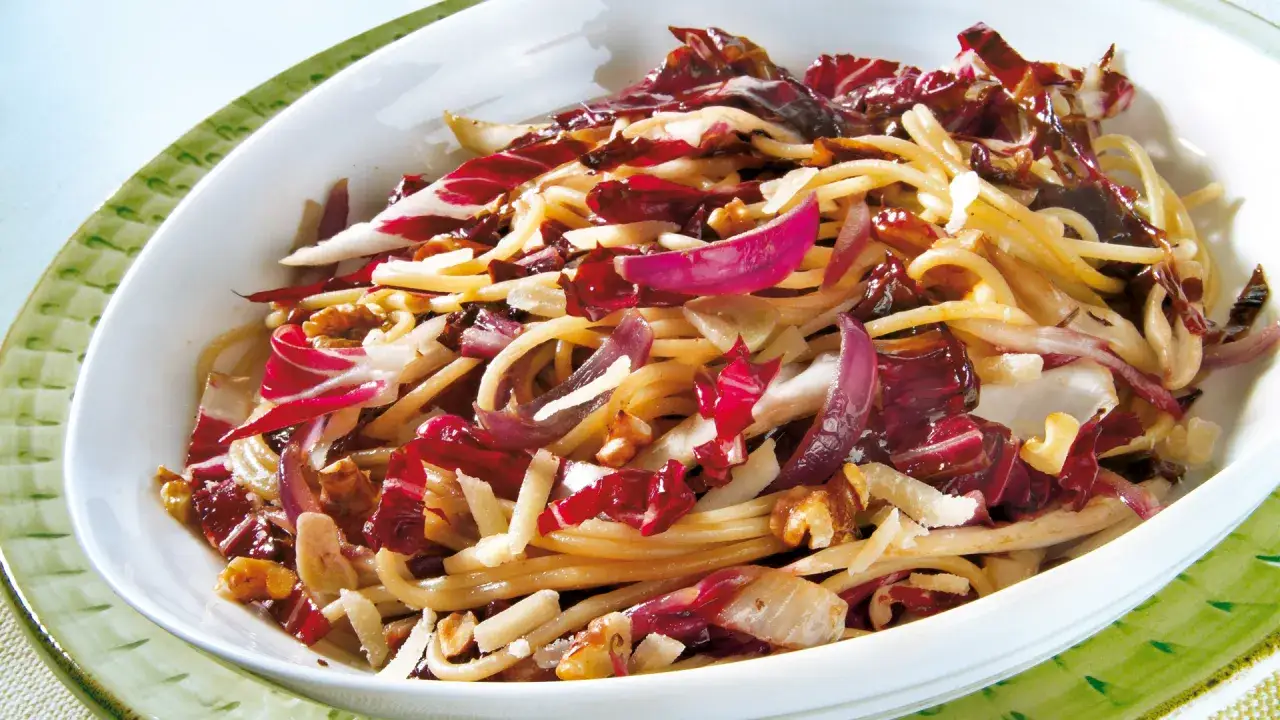 Ein köstliches Radicchio-Rezept italienisch: Spaghetti mit Radicchio, Nüssen und Parmesan in einer weißen Schüssel.