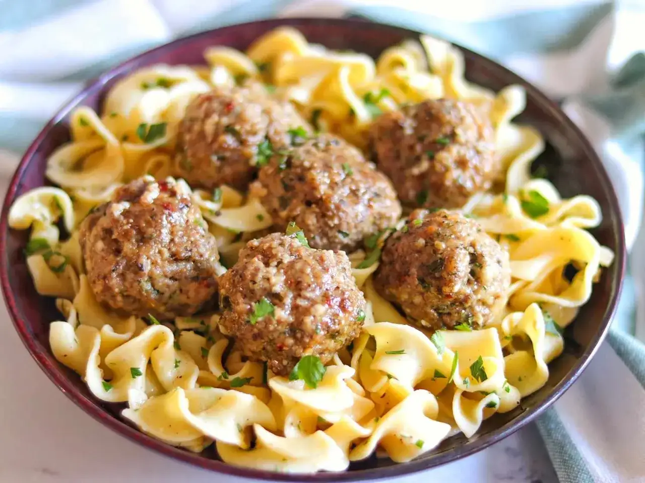 Herzhafte Fleischbällchen (polpette) auf Bandnudeln, garniert mit Petersilie. Ein einfaches und leckeres polpette rezept.