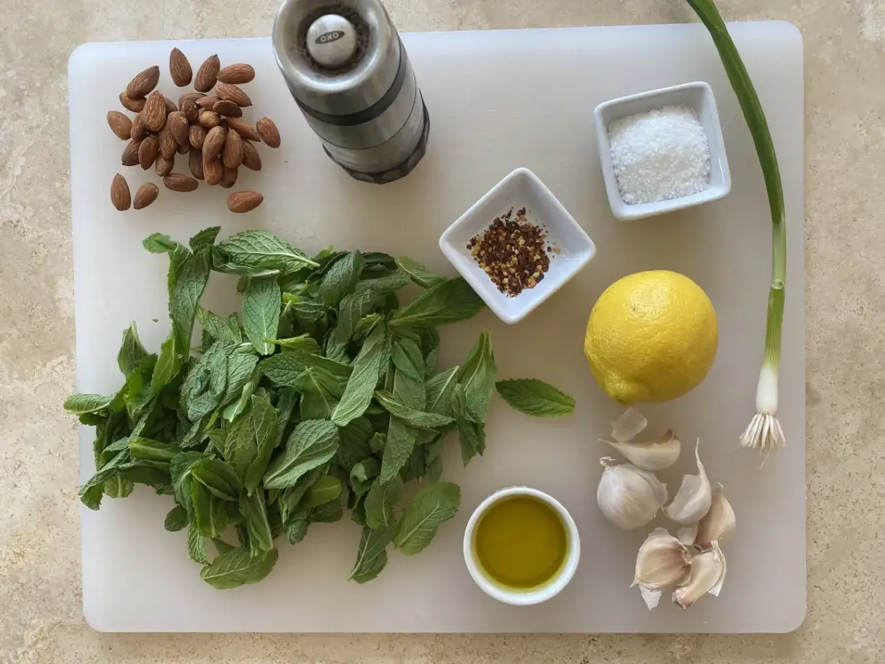 Zutaten f&uuml;r ein gremolata rezept original italienisch: Minze, Mandeln, Zitrone, Knoblauch, Oliven&ouml;l, Salz und Chili-Flocken.