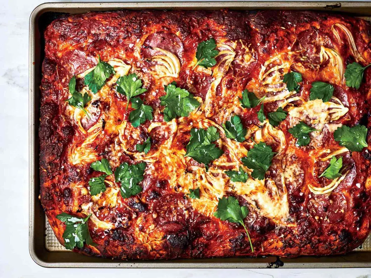 Herzhaftes italienisches Gericht mit Salami, Zwiebeln und K&auml;se, garniert mit Petersilie. Perfekt f&uuml;r Salami Rezepte Italienisch.