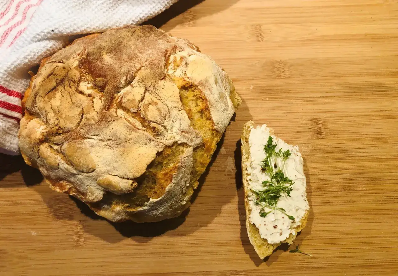 Ein rustikales, frisch gebackenes italienisches Brot Rezept, genial einfach. Daneben eine Scheibe Brot mit Frischk&auml;se und Kresse.