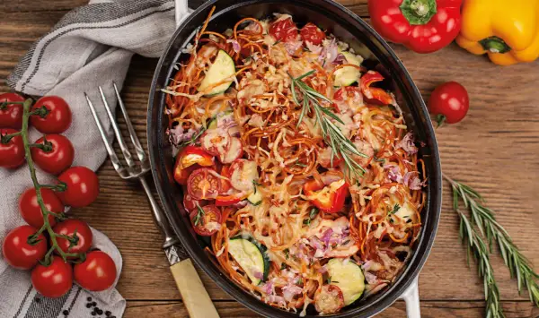Herzhaftes Spaghetti al Forno mit Tomaten, Zucchini und Paprika, überbacken mit Käse und garniert mit Rosmarin.