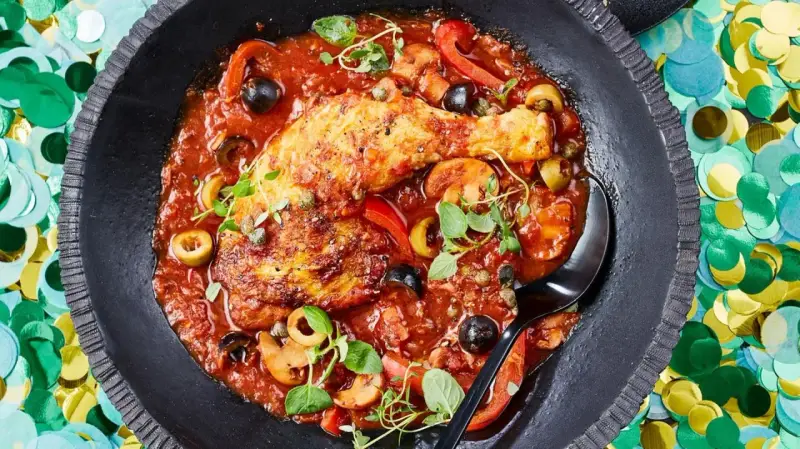 Herzhaftes Pollo Cacciatore in Tomatensauce mit Oliven, Kapern und Pilzen, garniert mit frischen Kräutern.