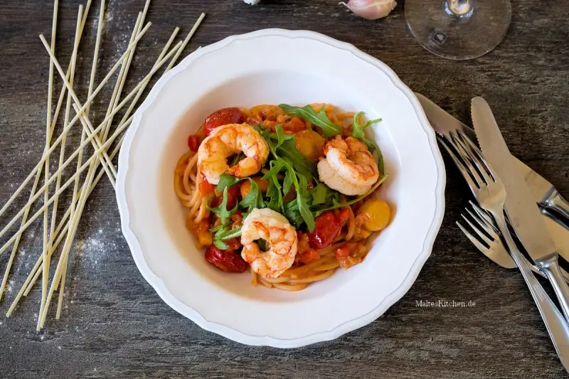 Ein köstliches garnelen italienisch rezept: Spaghetti mit Garnelen, Kirschtomaten und Rucola in einer cremigen Sauce.