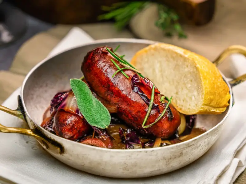 Herzhafte italienische Bratwurst Salsiccia mit Rotkohl und Brot. Ein köstliches Rezept für Salsiccia.