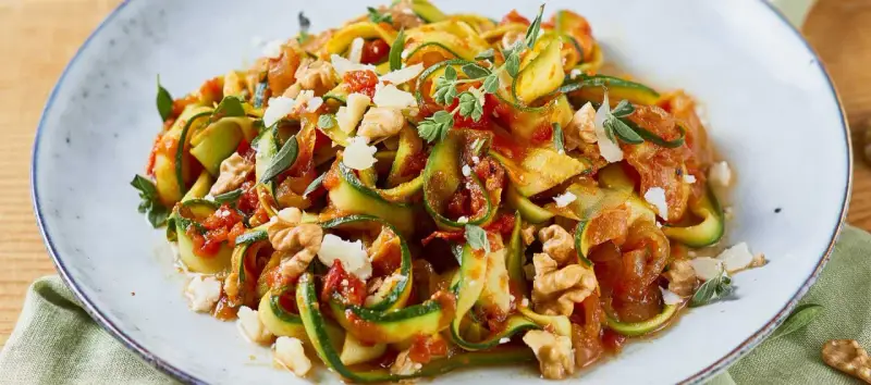 Zucchini-Nudeln mit Tomatensoße, Walnüssen und Parmesan. Ein leichtes Gericht, perfekt für Zucchini Rezepte.