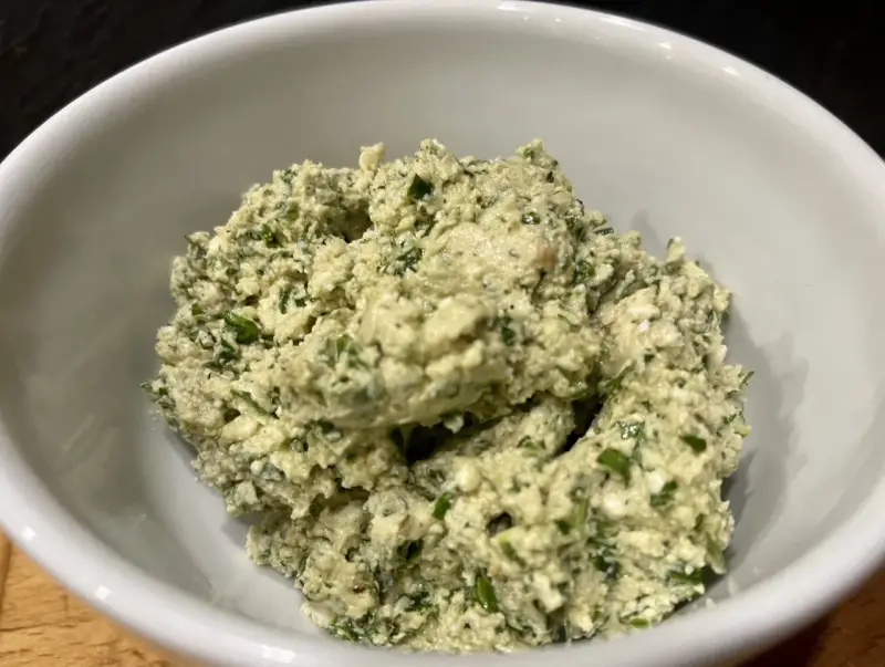 Ein cremiger Käseaufstrich mit Kräutern, wie er für ein Moretum Rezept typisch ist.